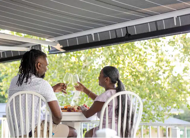Couple enjoying glass of wine under a double retractable awning